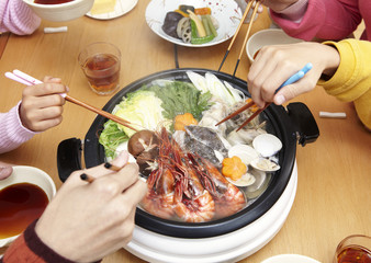 Family's hands sitting around yosenabe