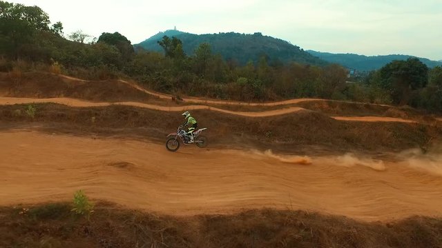 Aerial: Man riding a bike on motocross track.