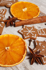 Fresh baked decorated gingerbread with spices on old wooden background, christmas time