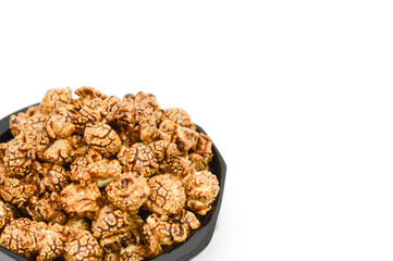 Chocolate popcorn in black bowl on white background and copy spa