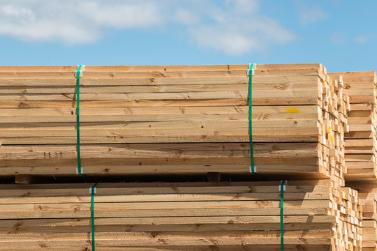 stack of wooden planks against blue sky