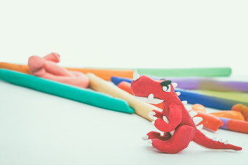 Creative red dinosaur clay model. Play dough animal. Vintage tone