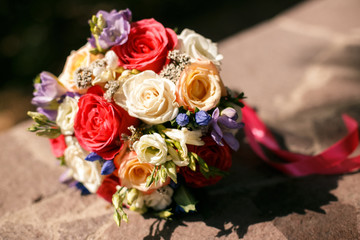 colorful bridal bouquet lying on the stone slabs