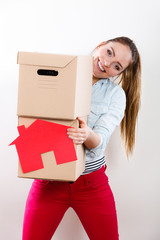 Woman moving into home with boxes and paper house.
