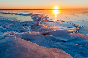 crack in the ice on a frozen lake at sunset