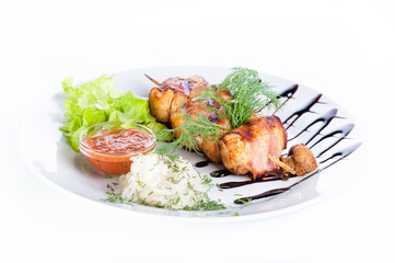 Skewers of beef and ham with parsley, onion and lettuce on a white background