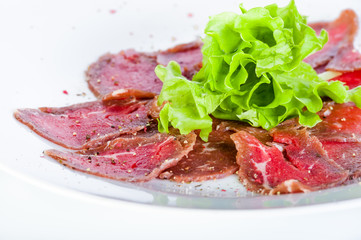 Carpaccio of beef with onions and spices on a white background