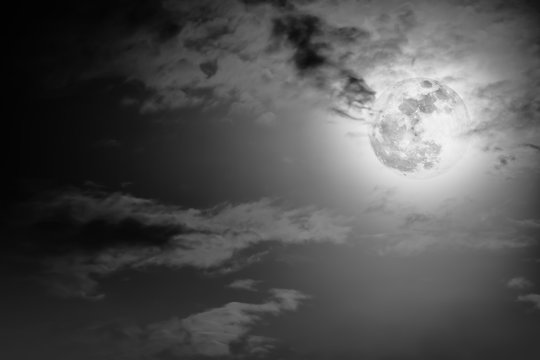 Nighttime sky with clouds and bright full moon with shiny.