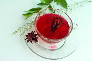 Glass of cold roselle juice - healthy food against wood