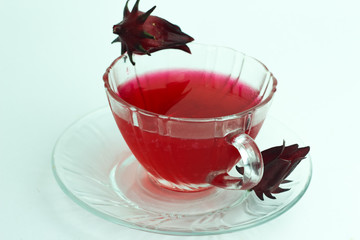 Glass of cold roselle juice - healthy food against wood