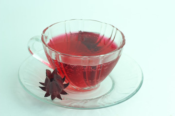 Glass of cold roselle juice - healthy food against wood