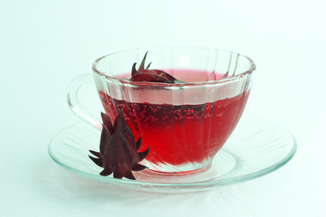 Glass of cold roselle juice - healthy food against wood