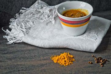 cup of steaming hot soup with spices on raw cotton embroidered t