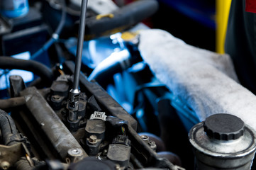 Mechanic fixing a car's engine with a wrench