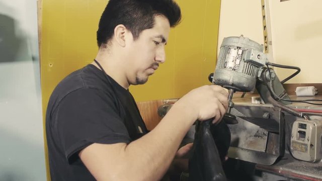 Shoemaker works with polish machine