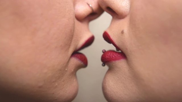 Women couple red lips kissing each other detail close up