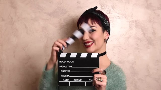 Young woman actress using movie clapper board audition