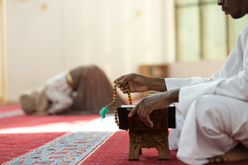 Hand of muslim black man people praying with mosque interior background