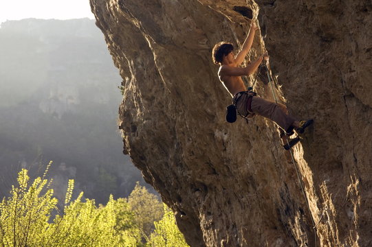 A climber tackles a very difficult route on the rock known as Dromadaire (The Dromedary) by the Tarn river, Gorges du Tarn, near Millau and Rodez, Massif Central, south west France
