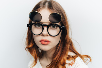 Fototapeta premium Portrait of a girl in glasses on a light background 