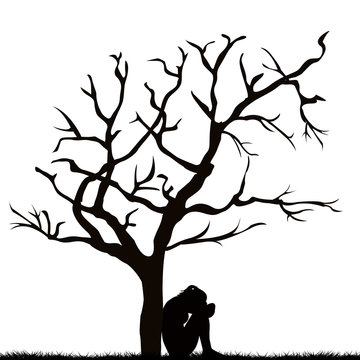 Silhouette of a sad woman under a leafless tree