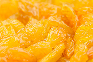 Fototapeta na wymiar Raisins yellow closeup background. Heap of shiny golden yellow raisins dried fruit.