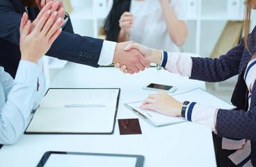 Business handshake. Two businesspeople shaking hands with each other in the office.