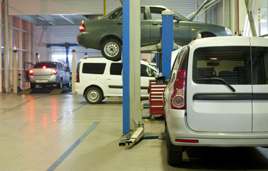 Detail of auto service garage. Back lights the nearest car and back window white  car is changed.