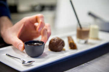 Fototapeta na wymiar Chef's hands composing a chocolate dessert
