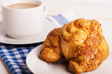 Breakfast with cup of coffee and croissant