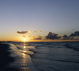 Fototapeta na wymiar Cloudy orange sunset over sea water, sunset over sea waves. .