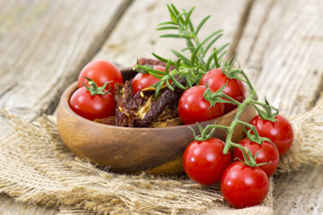 fresh and dried tomatoes on wooden background