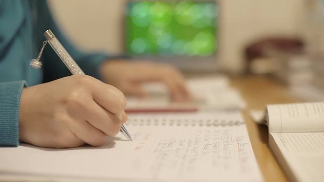 teen girl sat at home doing her homework