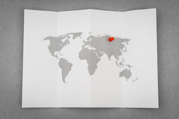 Paper folded world map  with red Pin Pointer .