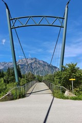 Pedestrian bridge over the Salzach river in Puch, not far from Salzburg city. In the background the mountain Untersberg. Puch, Austria, Europe. © utamaria