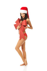 Santa woman standing and covering her body by ribbon, looking like a gift