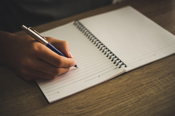 Man hand with pen writing on notebook.