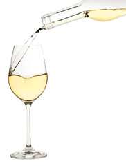 Glass of white wine is poured from a bottle