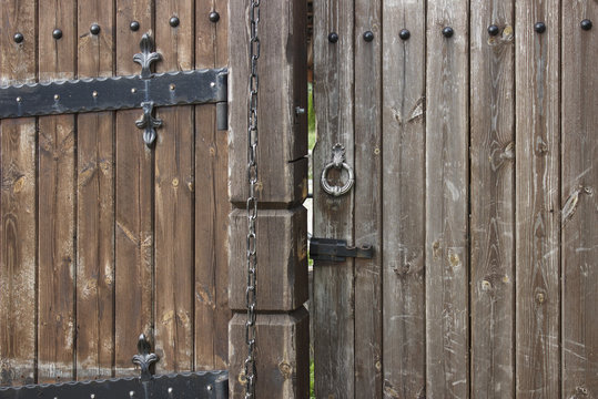 Wooden gate with bolt, metal handle and chain