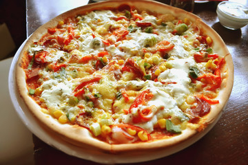 whole italian pizza on wood table with ingredients
