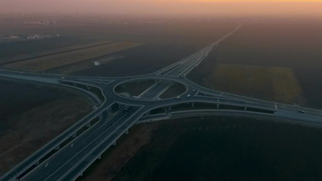 aerial view of traffic on the road crossing at sunset
