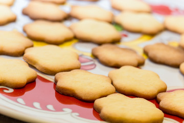 Biscotti artigianali a forma di fiore su piatto natalizio