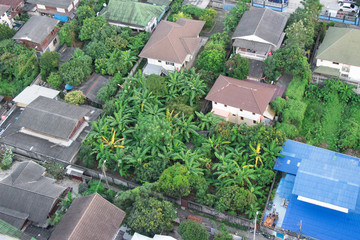 Fototapeta na wymiar Rooftop photo of a small neighborhood in the south-west corner of Bangkok. You can see palm trees mixed with housing in a nice relaxing neighborhood.