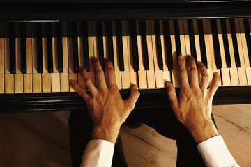 Man hands playing piano, close up