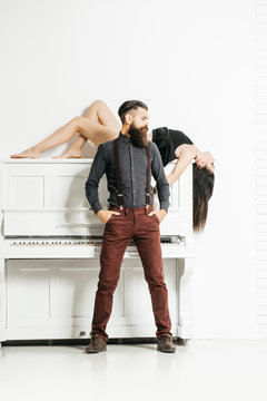 bearded man and girl with piano