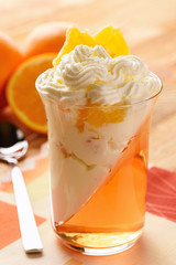 Orange jelly with whipped cream and orange fruit.