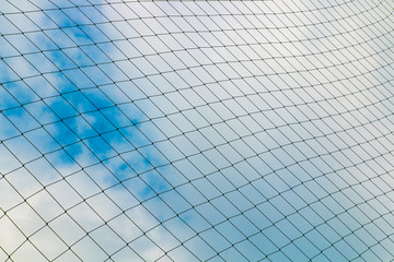 Background of soccer goal nets against blue sky