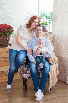 happy family, poses on a chair interior of studio