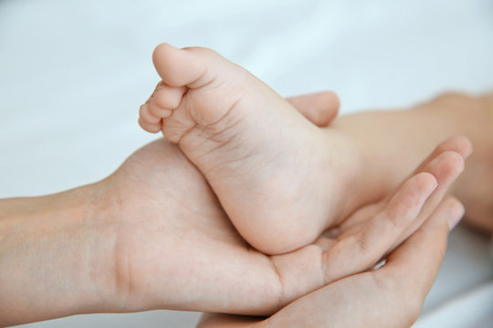 Mother holding foot of her baby  closeup