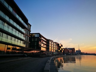 Moderne Bürogebäude mit spiegelnder Glasfassade im Licht der aufgehenden Sonne am Kreativkai an der Hafenpromenade am Hafen von Münster in Westfalen am Dortmund-Ems-Kanal im Münsterland